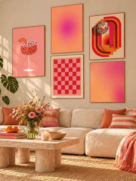 Bunte Bilderwand im Wohnzimmer über dem Sofa mit fünf Postern in Rosa und Orange